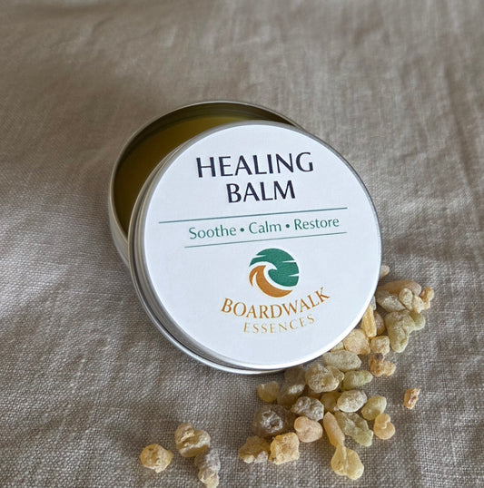Healing Balm 50g aluminium tin with cream label and gold border arranged with gentle botanical elements